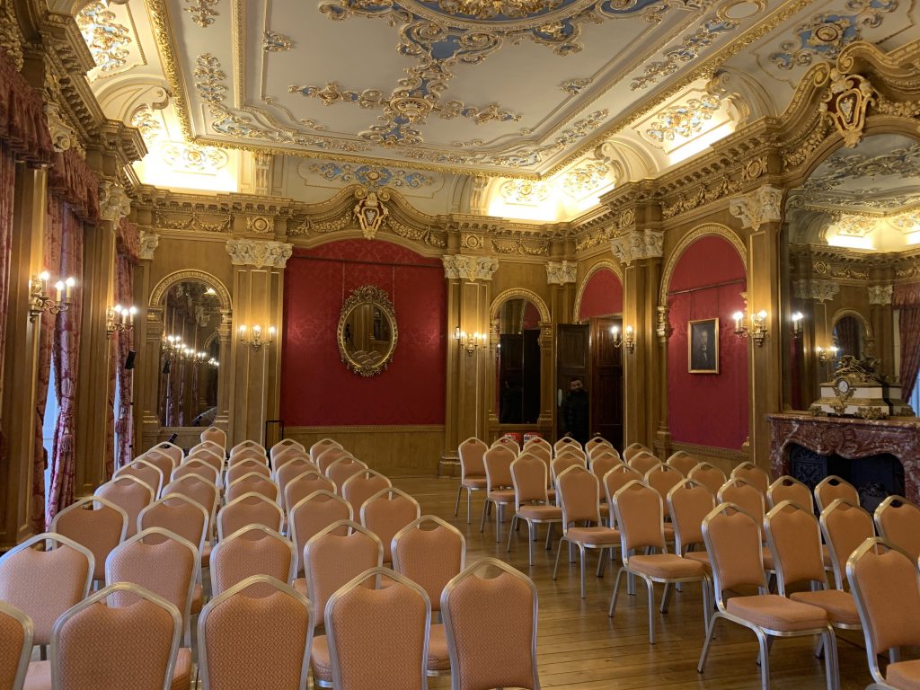 The lavish Banqueting Room at Hylands House, decorated in rich reds and gilt gold.