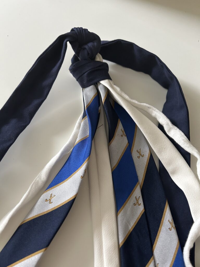 Handfasting chords that consist of surgical scrubs, a hockey club tie, a piece of wedding dress fabric and a piece of baby's first outfit.