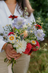 A mixed bunch of colourful flowers are presented as a wedding bouquet