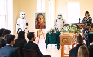 2 storm troopers stand to attention at a funeral ceremony