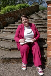 Shelley Bell siting on some steps with a notebook in hand
