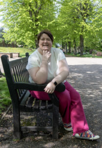 Shelley bell sitting on a park bench smiling into the camera