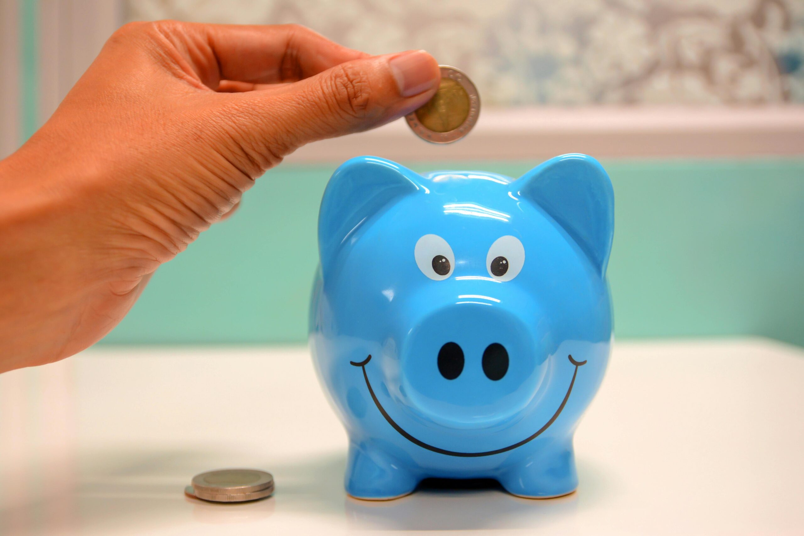 a blue piggy bank is smiling as coins are added