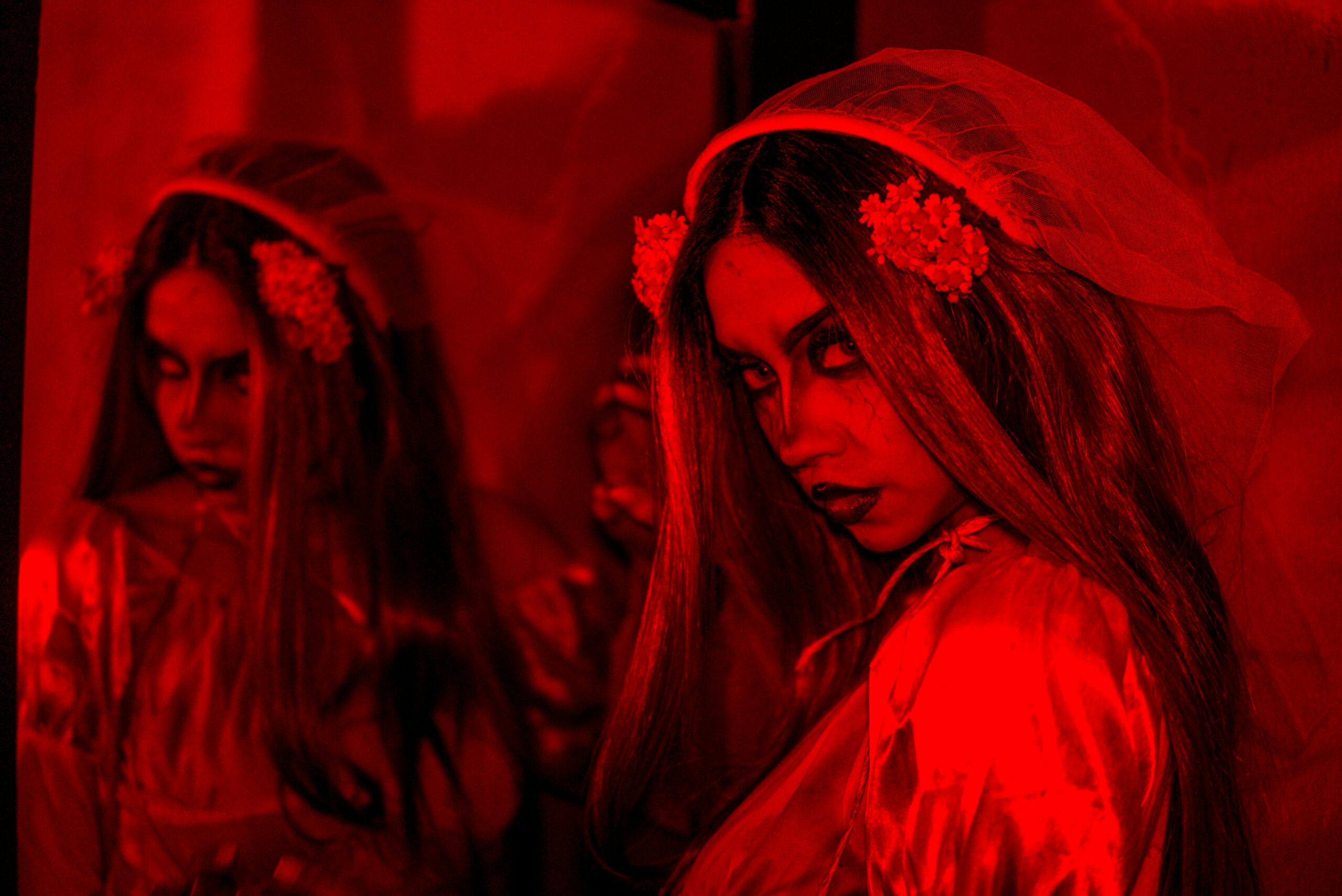 A bride is bathed in red light representing the horror of Friday 13th but not the joy of the Divine feminine or Valentine's Day.